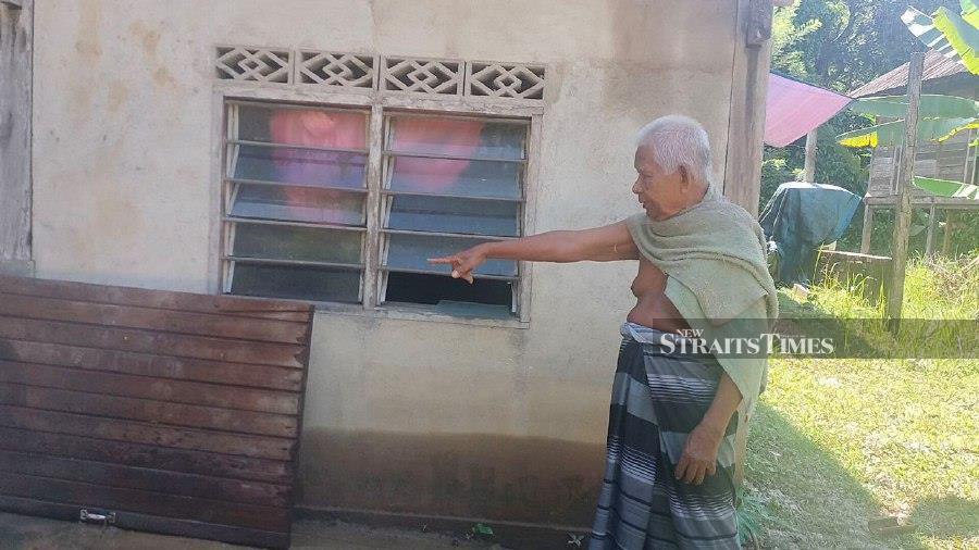 Che Noor Man shows a door of his home that was detached following the floods in Baling. -NSTP/Noorazura Abdul Rahman