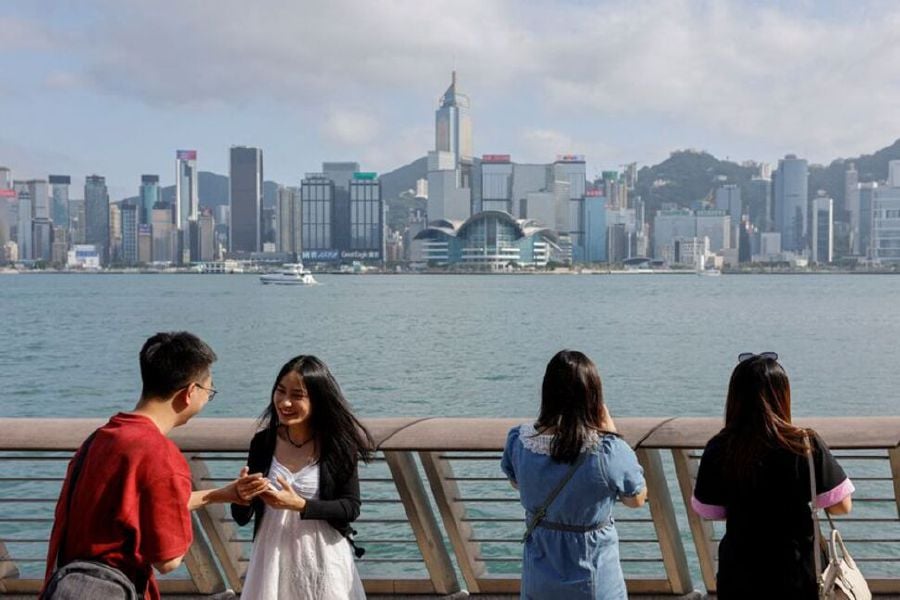FILE PHOTO: Mainland Chinese tourists take photo of the skyline of buildings at Tsim Sha Tsui, in Hong Kong, China May 2, 2023. REUTERS/Tyrone Siu/File Photo