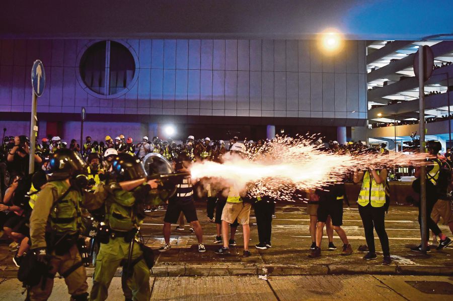 A policeman fires tear gas at protesters to disperse them after a march against a controversial extradition bill in Hong Kong on July 21, 2019. - AFP FILE PIC