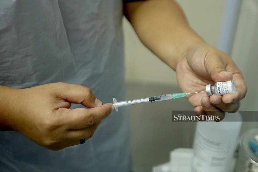 A health worker handles the Covid-19 vaccine at a clinic in Kuala Selangor recently. - NSTP file pci 