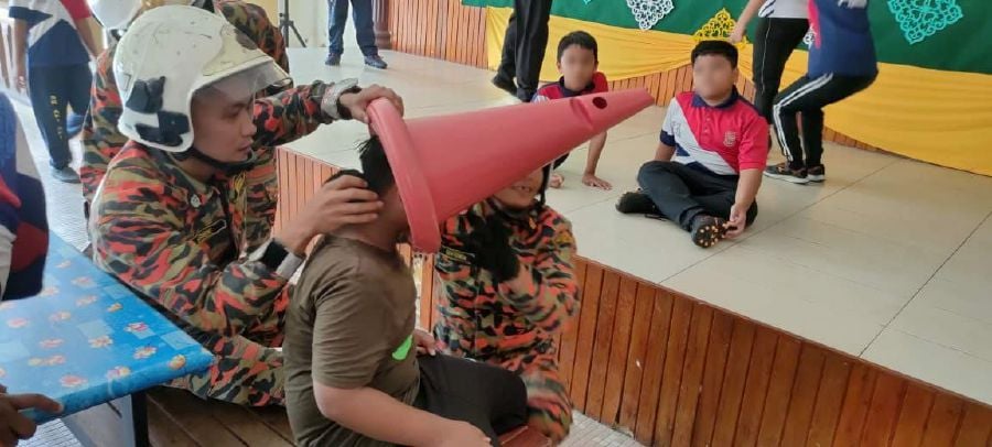 A team from the Pontian Fire and Rescue Department here was called to the remove a traffic cone that got stuck on a boy's head. - Pic courtesy of Bomba.