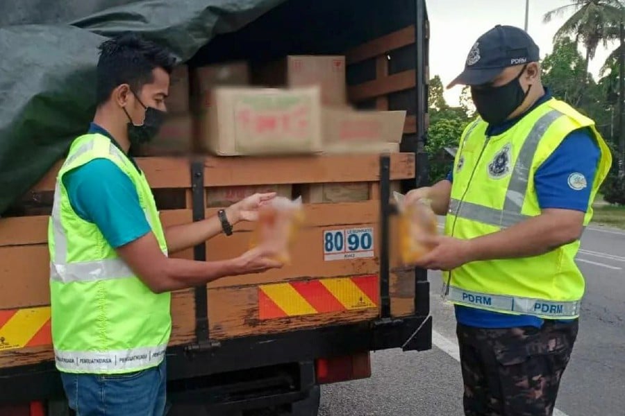 A lorry driver and his attendant were detained for possessing 2,720kg of 1kg cooking oil polybags worth RM68,000 believed to be for smuggling into Thailand. - Piv courtesy of Domestic Trade and Consumer Affairs Ministry
