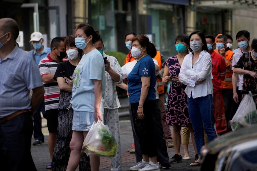 People line up for nucleic acid tests on a street, amid new lockdown measures in parts of the city to curb the coronavirus disease (COVID-19) outbreak in Shanghai, China, June 11, 2022. - Reuters file pic