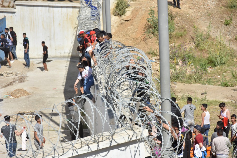 Migrants climb the fence in the northern town of Fnideq in an attempt to cross the border from Morocco to the Spanish enclave of Ceuta, in North Africa. - EPA pic