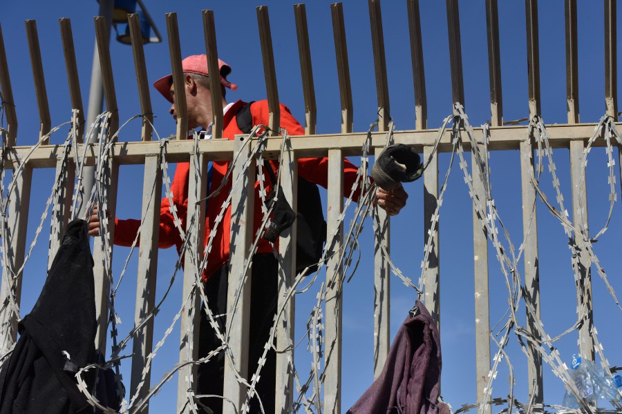 Migrants sneak through the fence in the northern town of Fnideq in an attempt to cross the border from Morocco to the Spanish enclave of Ceuta. - EPA pic