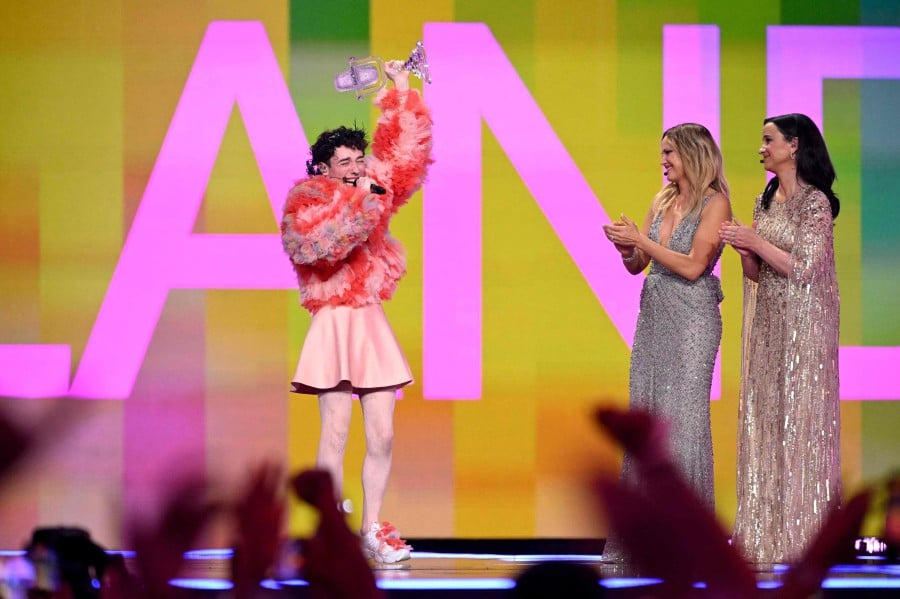 Swedish actress and presenter Petra Mede (R) and Swedish-US actress and presenter Malin Akerman applaud as winner Swiss singer Nemo (L) celebrates after the final of the 68th Eurovision Song Contest (ESC) 2024 on May 11, 2024 at the Malmo Arena in Malmo, Sweden. -- AFP