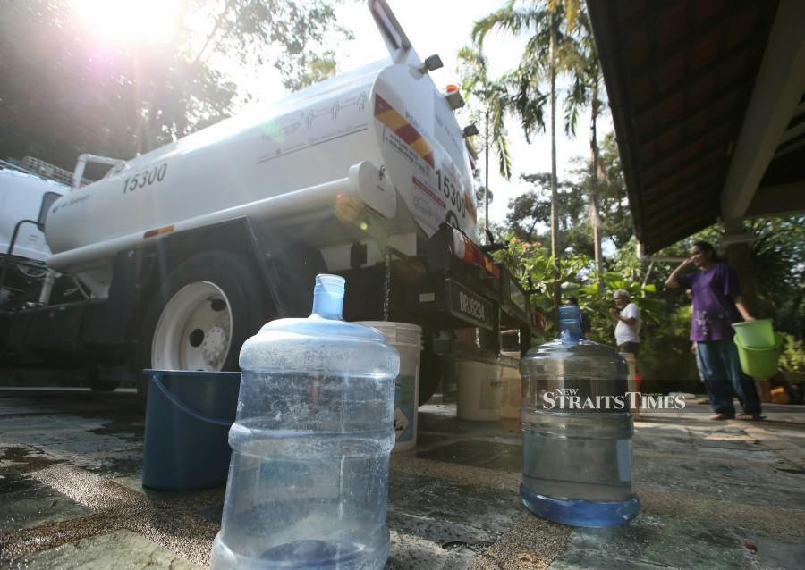 Residents in Kampung Sungai Penchala waiting to collect water following the water crisis. -NSTP/EIZAIRI SHAMSUDIN