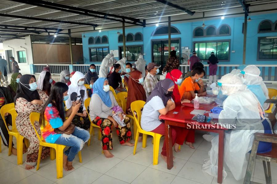 Residents of Kampung Bahagia registering for Covid-19 screening in Sandakan. - BERNAMA pic