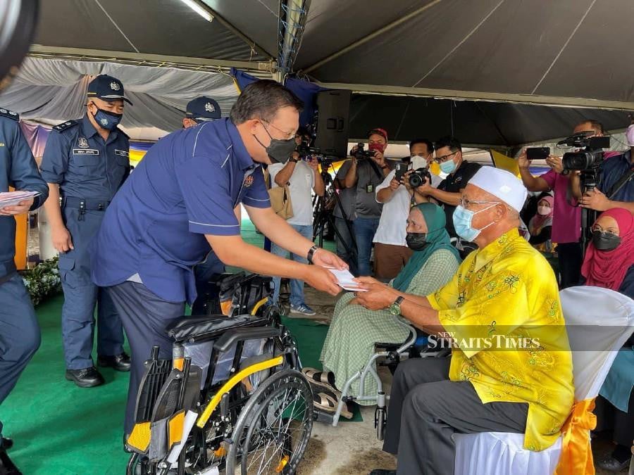 Chief Secretary to the Government Tan Sri Mohd Zuki Ali handing out aid during the Jalinan Kasih Keluarga Malaysia programme at Sekolah Kebangsaan Bukit Bayas, Kuala Terengganu. -NSTP/ZATUL IFFAH ZOLKIPLY