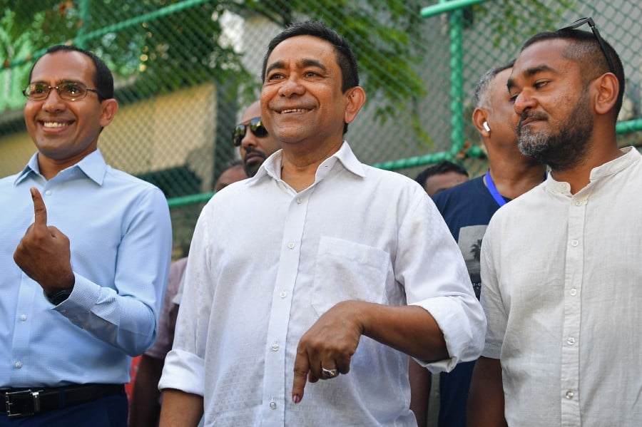 Former Maldives' President Abdulla Yameen (C) shows his inked marked finger after casting ballot during the country's parliamentary election, in Male on April 21, 2024. -- AFP