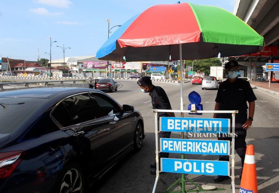 Police officers manning a road block at  Jalan Hamzah in Kota Baru. -NSTP/NIK ABDULLAH NIK OMAR