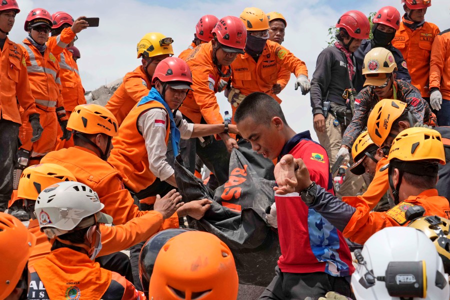 Rescuers recover the body of an earthquake victim from under the rubble of a collapsed building in Cianjur, West Java, Indonesia. - AP PIC