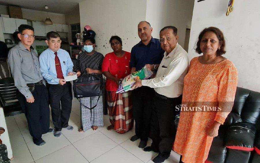 Three NGOs presenting Nagammal (fourth from right) with assistance that included a laptop for her daughter (third from left) in this pre-Deepavali period. - NSTP/VINCENT D’SILVA