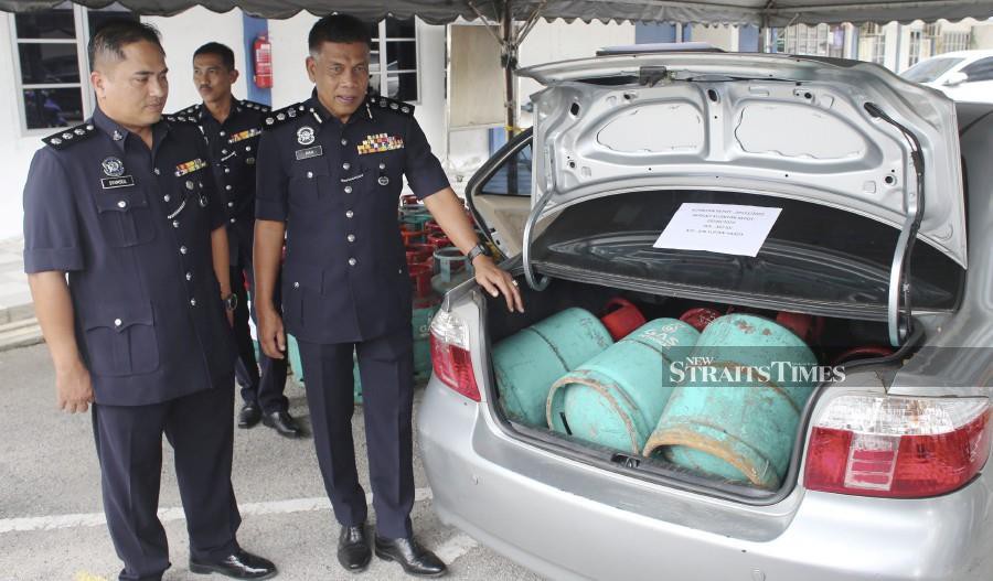 Kuantan District police chief Assistant Commissioner Wan Mohd Zahari Wan Busu showing some of the gas cylinders, hidden in a car, during a press conference at the Kuantan police headquarters. - NSTP/FARIZUL HAFIZ AWANG