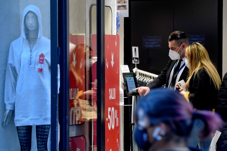  A security officer checks customers' green pass at the entrance to a clothing store in Naples, southern Italy. - EPA PIC