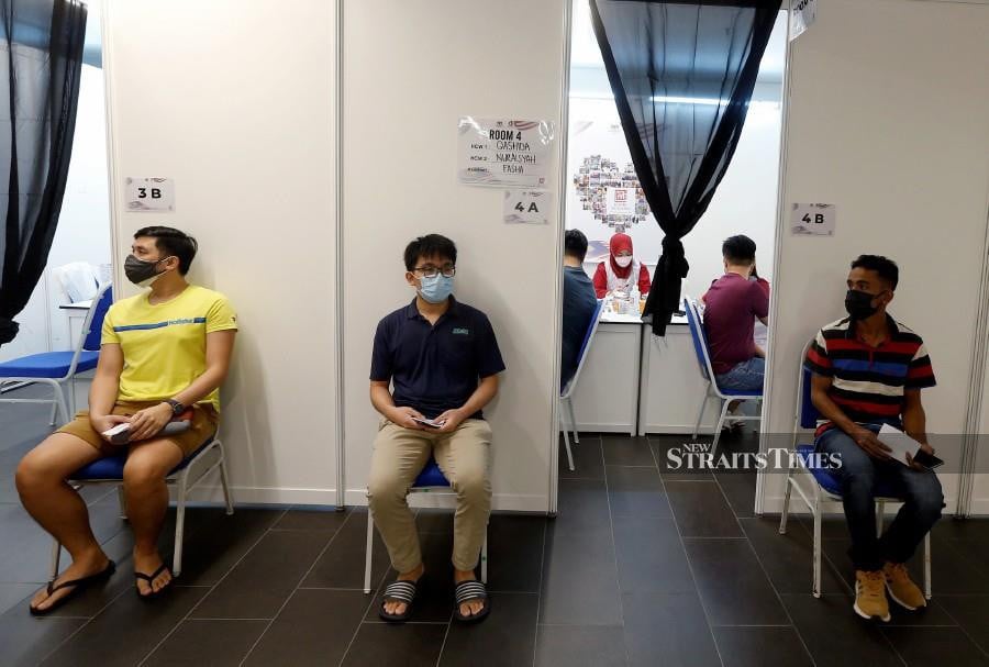Recipients waiting for their turn to take the Covid-19 vaccine booster shot at a vaccination centre in Kuala Lumpur. -- NSTP File Pic