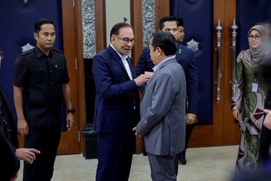 Prime Minister Datuk Seri Anwar Ibrahim speaks to Deputy Finance Minister I Datuk Seri Ahmad Maslan (right) ahead of the Dewan Rakyat sitting today. - BERNAMA PIC