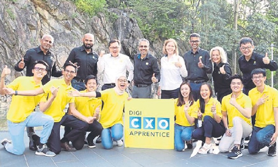 Digi’s chief officers (CXOs) with eight talented young Malaysians, who were