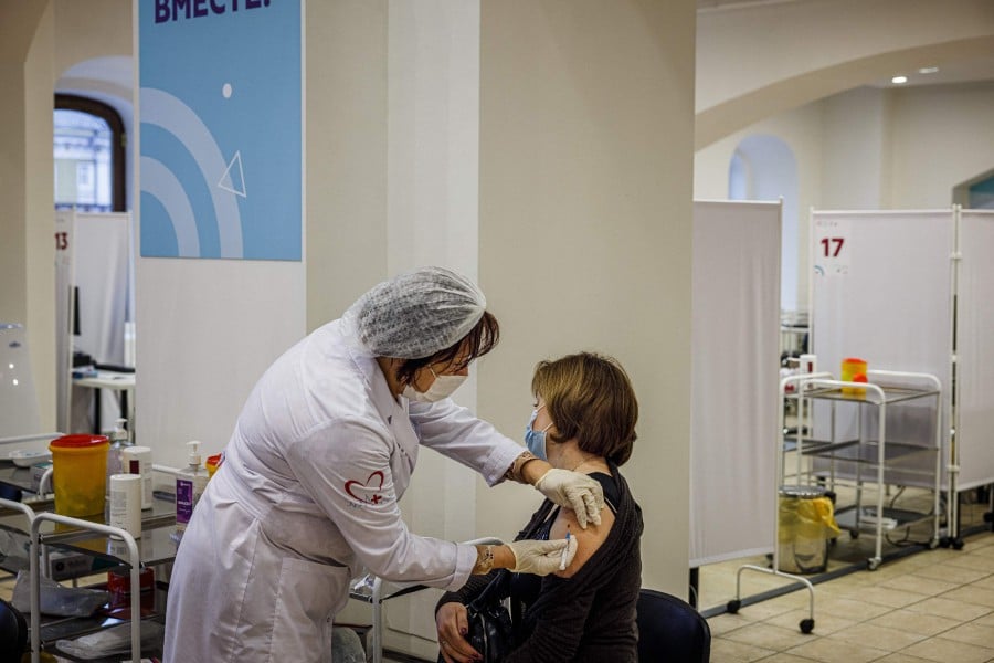 A healthcare worker administers a dose of Russia's Sputnik V Covid-19 vaccine to a patient at a vaccination centre in the GUM State Department store in Moscow. - AFP PIC