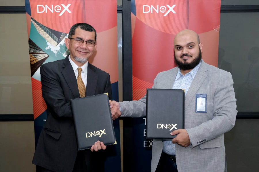 (From left) Dagang NeXchange Bhd group managing director Tan Sri Syed Zainal Abidin Mohamed Tahir and AnalytX of Ajlan & Bros Holding Group chief executive officer Dr. Tariq Alshawi exchanging MoU documents.