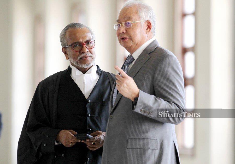 A file pic dated April 22, 2019, shows  Datuk Seri Najib Razak speaking to his lawyer Tan Sri Muhammad Shafee Abdullah, during the  SRC International trial at the Kuala Lumpur Courts  Complex, - NSTP file pic