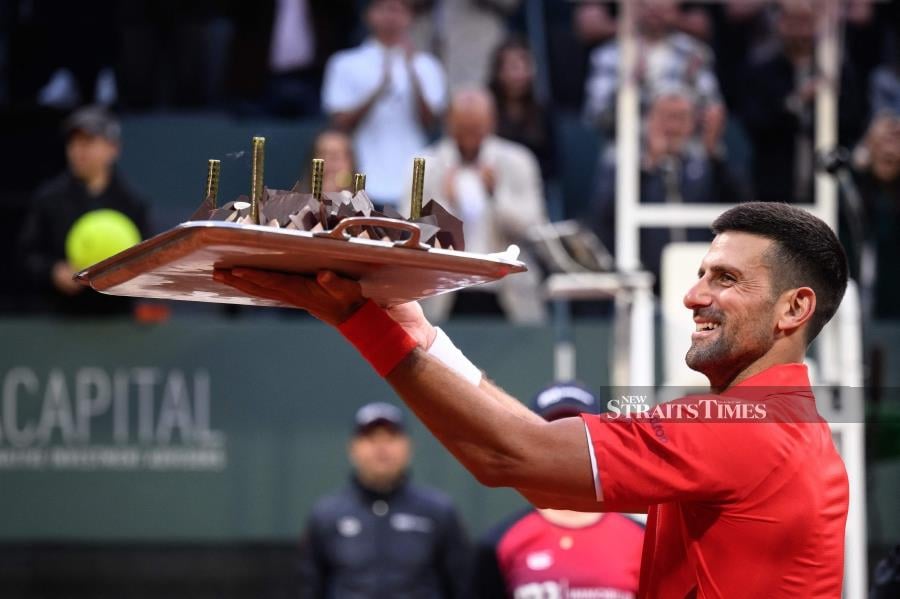 Novak Djokovic reacts with his birthday cake after winning his Geneva Open match against Yannick Hanfmann, in Geneva, yesterday. - AFP PIC