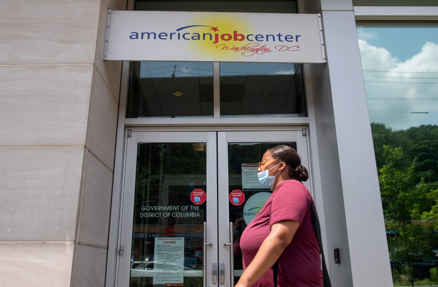 A woman walks past the the DC Department of Employment Services American Job Center, which assists in finding employment for out of work DC residents, in Washington, DC. - AFP pic