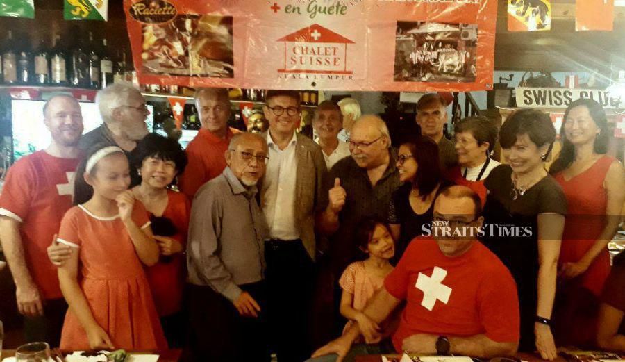 Jacques Baudevin (centre, white shirt) and Manfred J. Faehndrich (on his left) with guests at the Swiss national day reception at the Chalet Suisse Restaurant in One Ampang Avenue, Kuala Lumpur. - Pic by ADRIAN DAVID