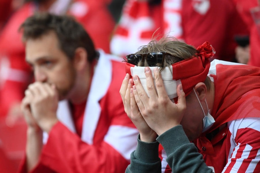 Fans react in the crowd after Denmark's midfielder Christian Eriksen collapsed on the pitch during the UEFA EURO 2020 Group B football match between Denmark and Finland at the Parken Stadium in Copenhagen. -AFP Pic