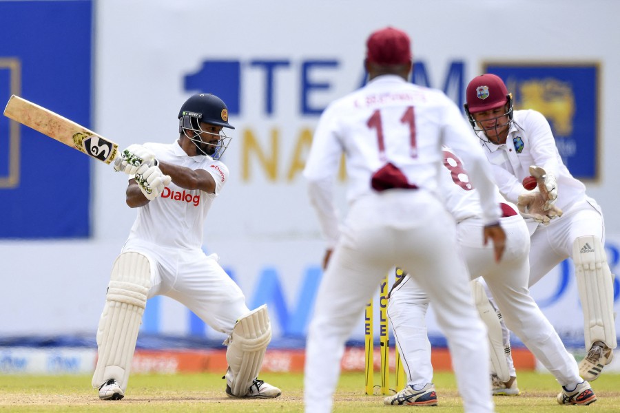 Sri Lanka's captain Dimuth Karunaratne (L) plays a shot during the fourth day of the first Test cricket match between Sri Lanka and West Indies at the Galle International Cricket Stadium in Galle. - AFP PIC