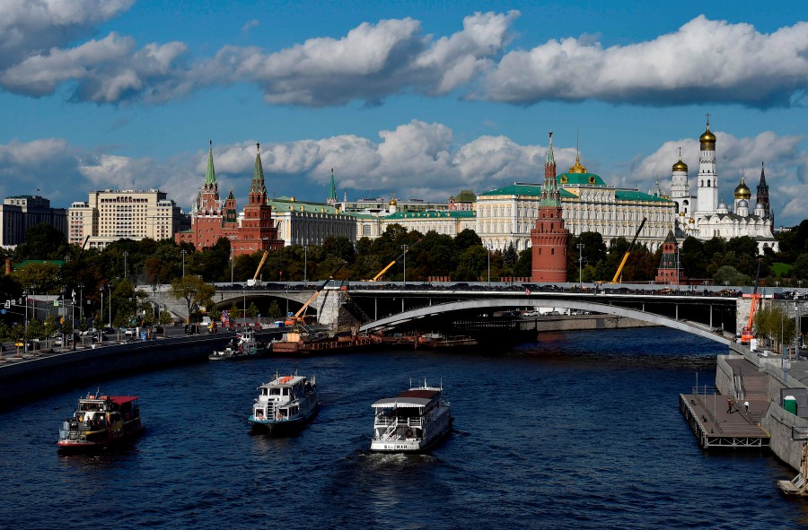 Tourist boats float on the Moskva river in downtown Moscow, with the Kremlin seen in the background. - AFP pic