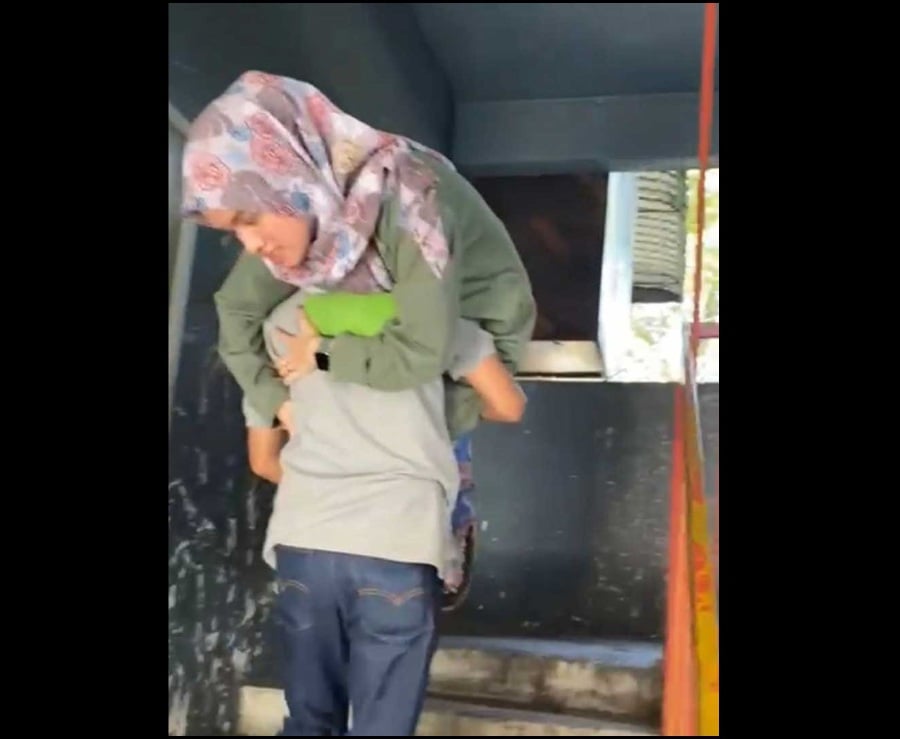 A 61-year-old father in Kota Damansara recently earned the praise of netizens after a compilation video of him carrying his daughter on his back was posted on TikTok. - Screengrab via social media