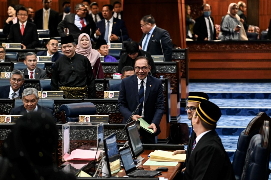 Prime Minister Datuk Seri Anwar Ibrahim shares a light moment during the Dewan Rakyat sitting today. - Pic courtesy of Information Department. 