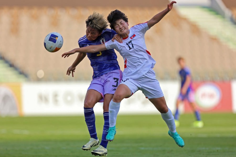 North Korea's forward Kim Kyong Yong and Japan's defender Moeka Minami vie for a header during the football match between North Korea and Japan at the AFC women's Olympic qualifying tournament 2024 at Prince Abdullah Al Faisal Stadium in Jeddah. - AFP PIC