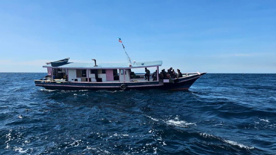 The Malaysian Maritime Enforcement Agency (MMEA) has stopped two fishing boats from illegally entering the country through Kudat waters that were carrying 43 people, including women and children, aged between 2 and 55 years-old. — PIC COURTESY OF MMEA