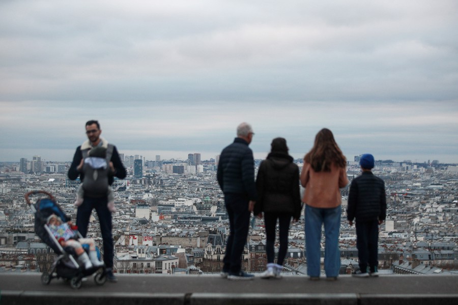  People stand next to the Sacred Heart Basilica looking toward the city of Paris, France. - EPA PIC