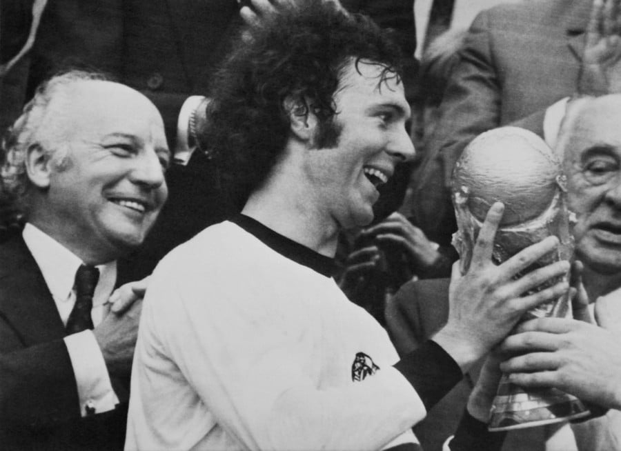 ) West German captain Franz Beckenbauer holds the trophy after his team's victory at the World cup final "West Germany - Holland" at Olympic Stadium in Munich on July 7, 1974. - AFP PIC