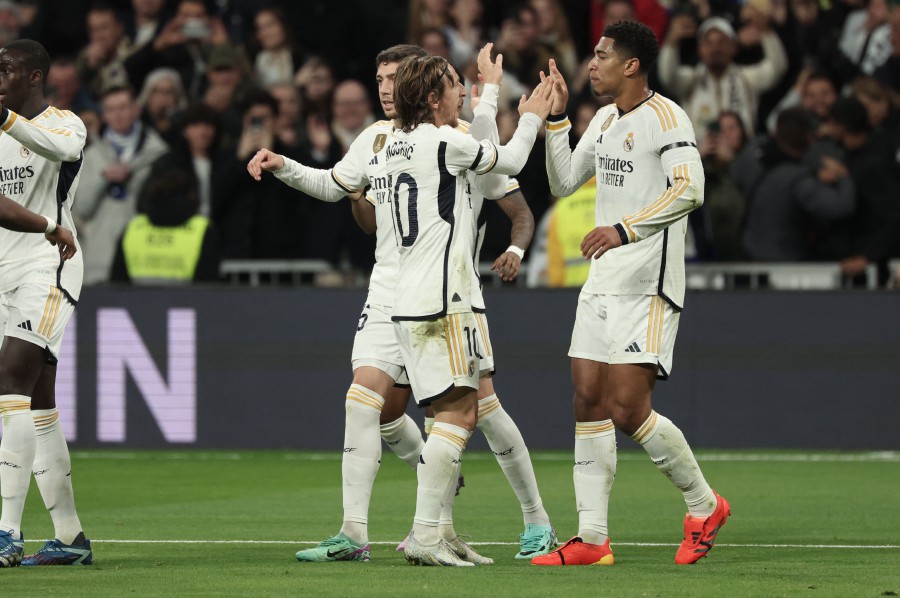 Real Madrid's Jude Bellingham (R) celebrates scoring the opening goal with teammates during the match against Villarreal at the Santiago Bernabeu stadium in Madrid. - AFP PIC