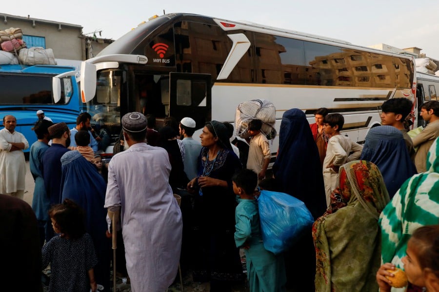 Afghan people gather to board a bus to return home, after Pakistan gave the last warning to undocumented migrants to leave, at a bus stop in Karachi, Pakistan. - REUTERS PIC
