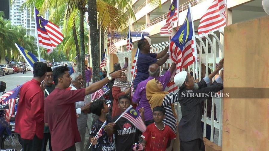 Residents of Mutiara Heights Apartments seen placing Jalur Gemilang around its compound, ahead of the National Day celebration. -NSTP/ZUHAINY ZULKIFFLI