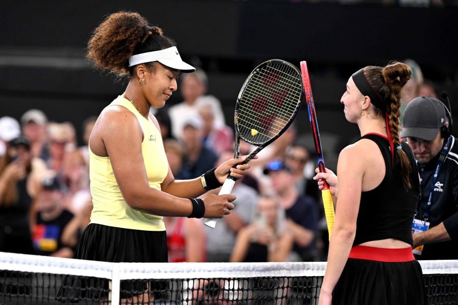 Japan's Naomi Osaka (L) bumps racquets with Germany's Tamara Korpatsch after victory during their women's singles match at the Brisbane International tennis tournament in Brisbane. - AFP PIC