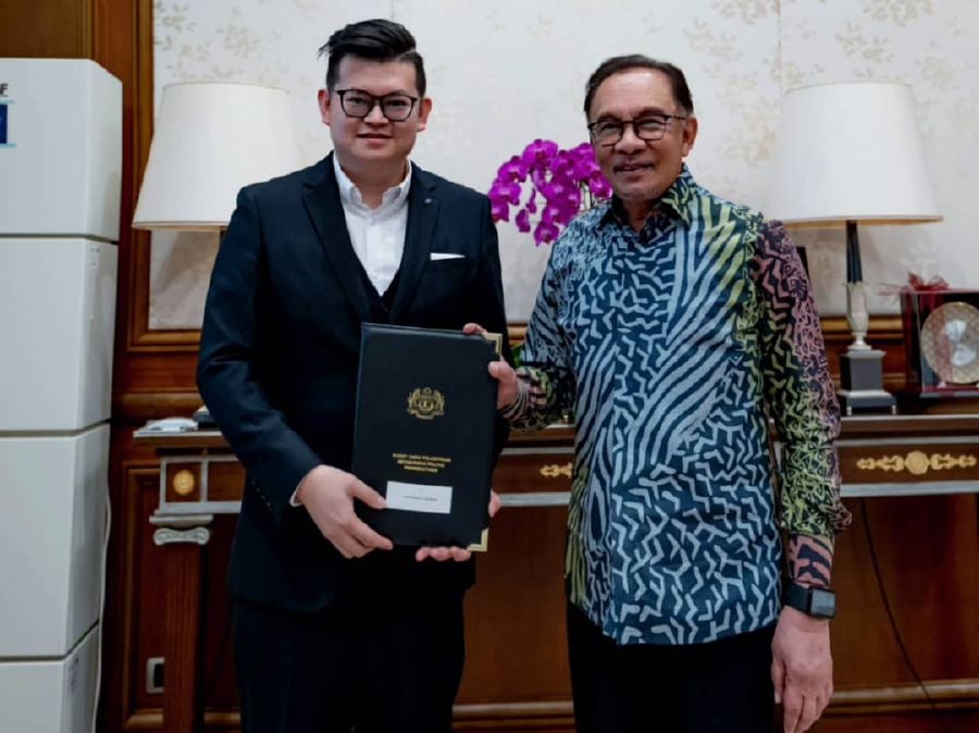 Prime Minister Anwar Ibrahim presenting the official appointment Dr Kelvin Yii.