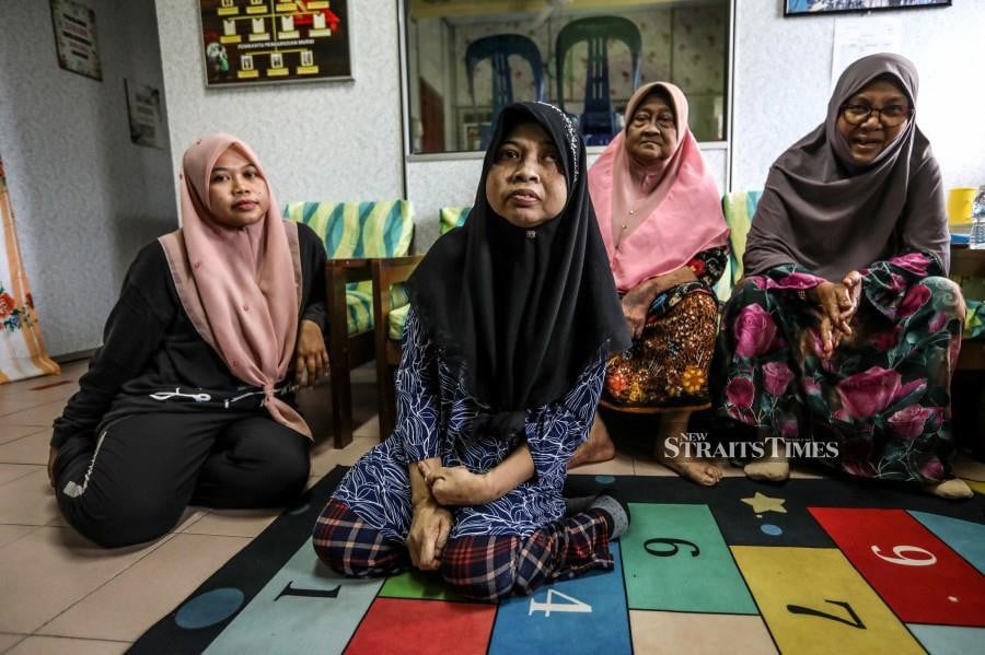 Zainiah Muda (2nd-left) with her family members seeking shelter at SK Pulau Serai. -NSTP/GHAZALI KORI