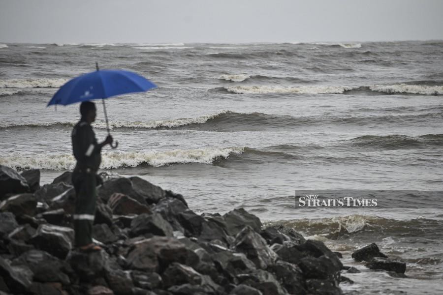 A man watches as strong waves hits the shores in Muara Kerteh following the northeast monsoon. -NSTP/GHAZALI KORI