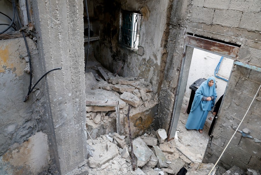 A Palestinian women looks at a destroyed house in the aftermath of an Israeli raid in Tulkarm, in the Israeli-occupied West Bank. - REUTERS PIC