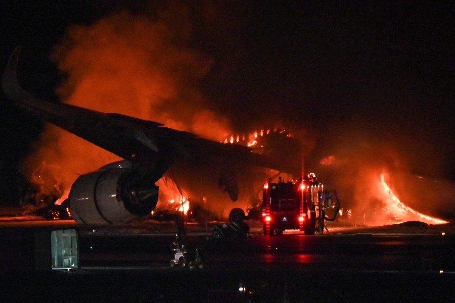 A Japan Airlines (JAL) passenger plane is seen on fire on the tarmac at Tokyo International Airport at Haneda. - AFP PIC