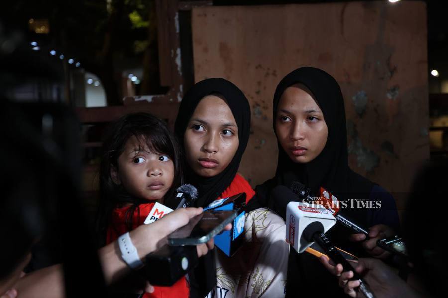 Nur Qistina Awliyah Mohd Azinoor (centre) and Nur Qistina Awliya speak to reporters at the Forensics Department of Hospital Raja Permaisuri Bainun. -NSTP/ASWADI ALIAS