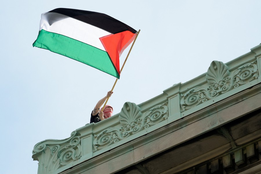 A student protester waves a Palestinian flag above Hamilton Hall on the campus of Columbia University, in New York. - REUTERS PIC