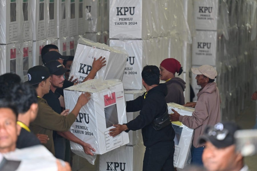 Workers unload boxes as the local election commission distributes election materials ahead of the general elections in Timika, Central Papua. - AFP PIC