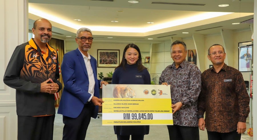Youth and Sports Minister Hannah Yeoh witnesses the presentation of the mock cheque by FAM deputy president Datuk Mohd Yusoff Mahadi to Perhilitan deputy director-general (Operations) Datuk Hasnan Yusop. - Pic credit Facebook FAMalaysiaOfficial